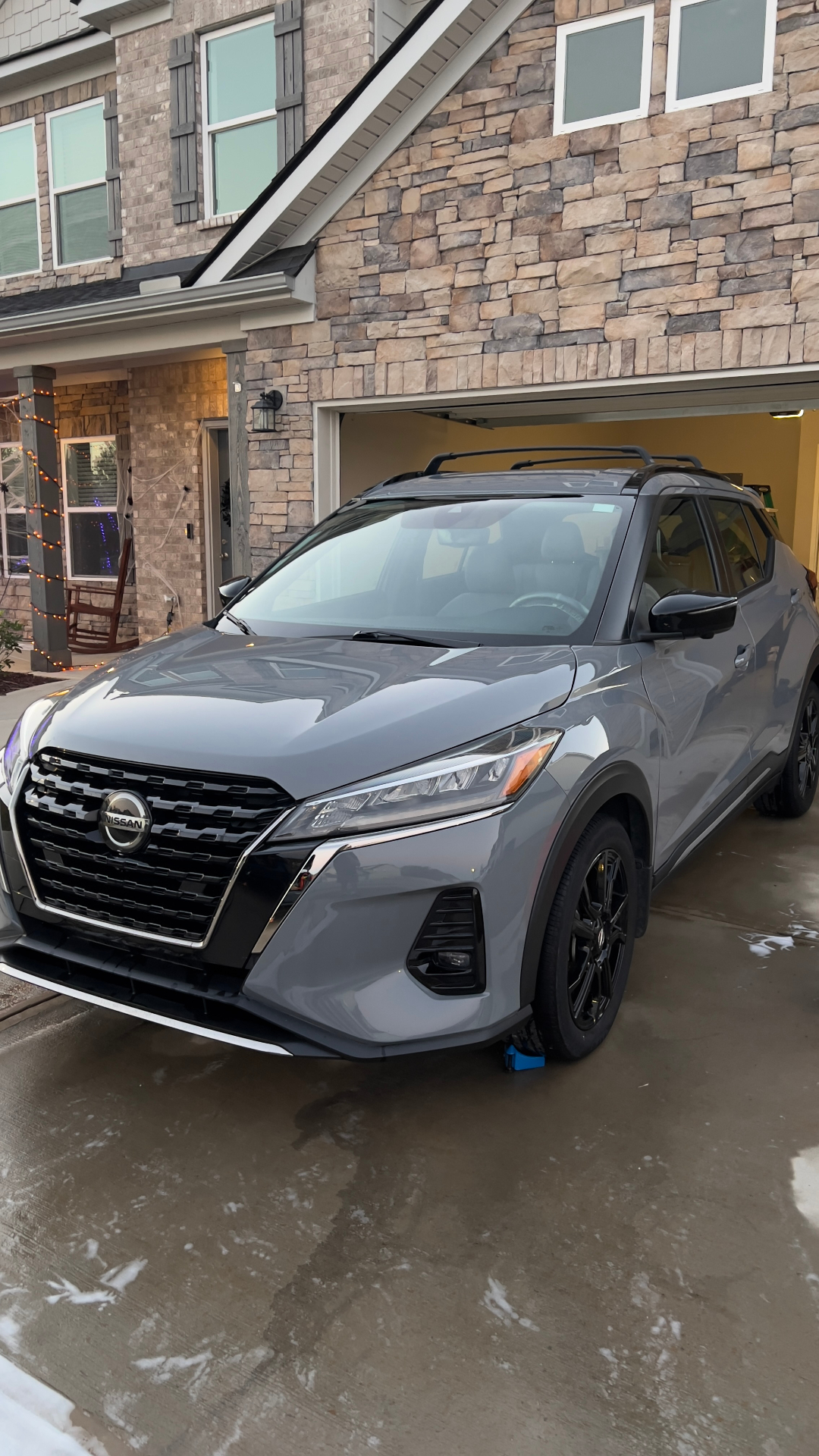 Glossy grey Nissan Kicks freshly washed in a driveway